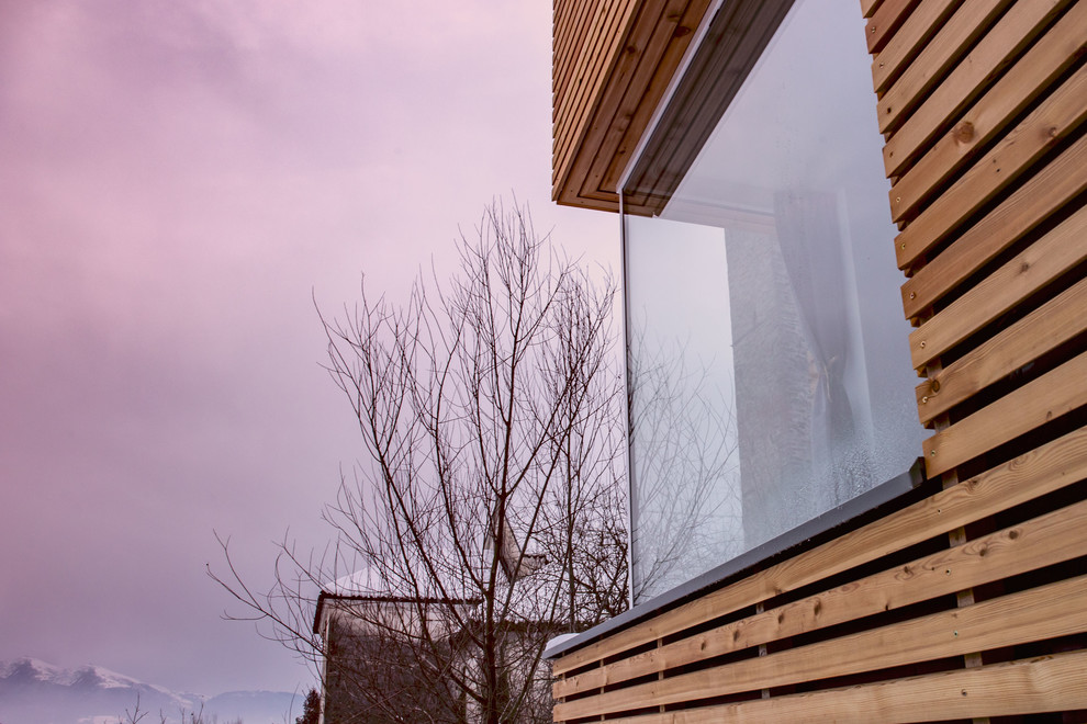 Réalisation d'une petite façade de maison design en bois à un étage avec un toit plat et un toit végétal.