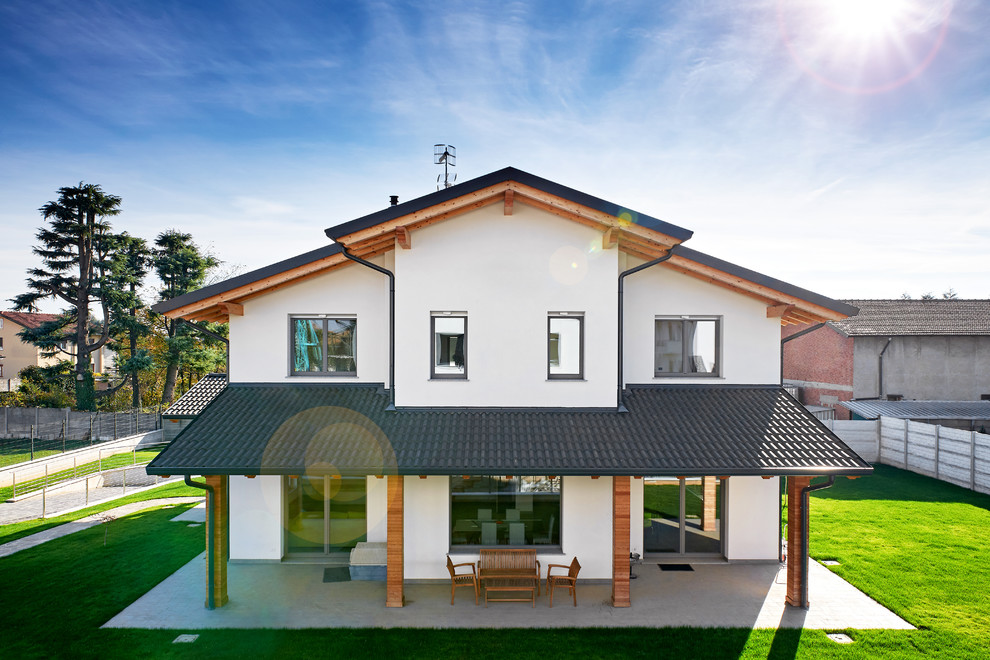Modelo de fachada de casa blanca tradicional grande de dos plantas con tejado a dos aguas y tejado de teja de barro