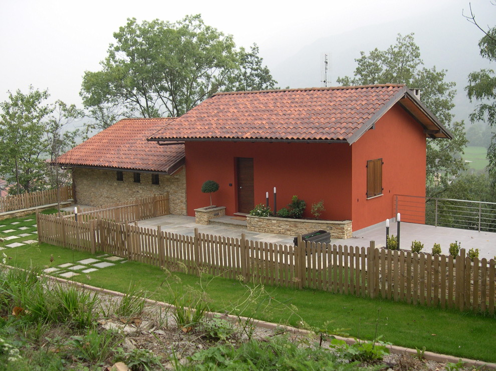 Immagine della villa rossa country a un piano con rivestimenti misti, tetto a capanna e copertura in tegole