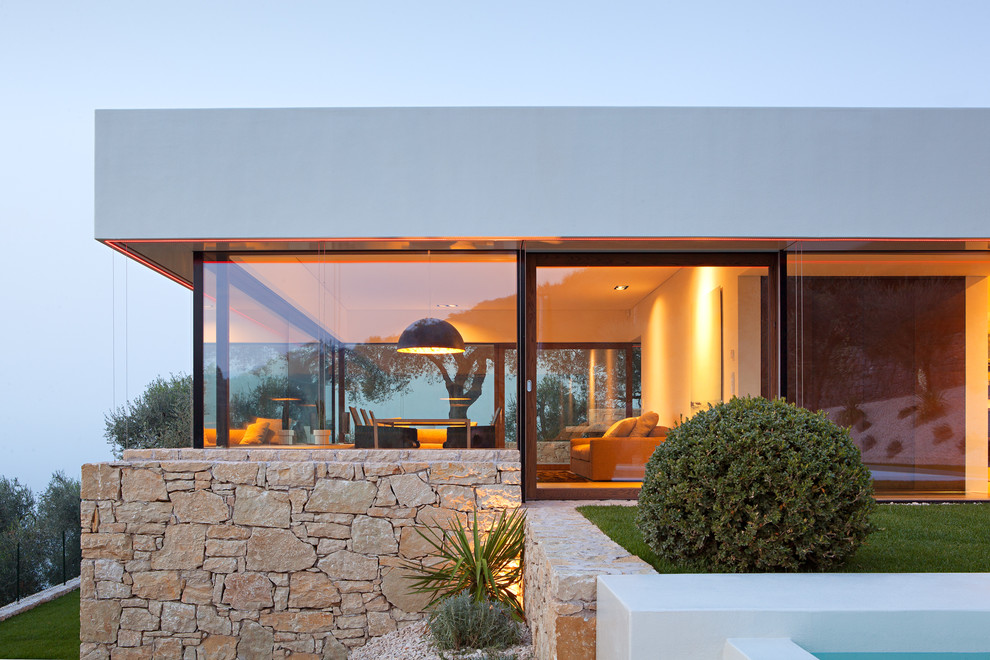 Inspiration pour une façade de maison blanche marine en pierre de taille moyenne avec un toit plat.