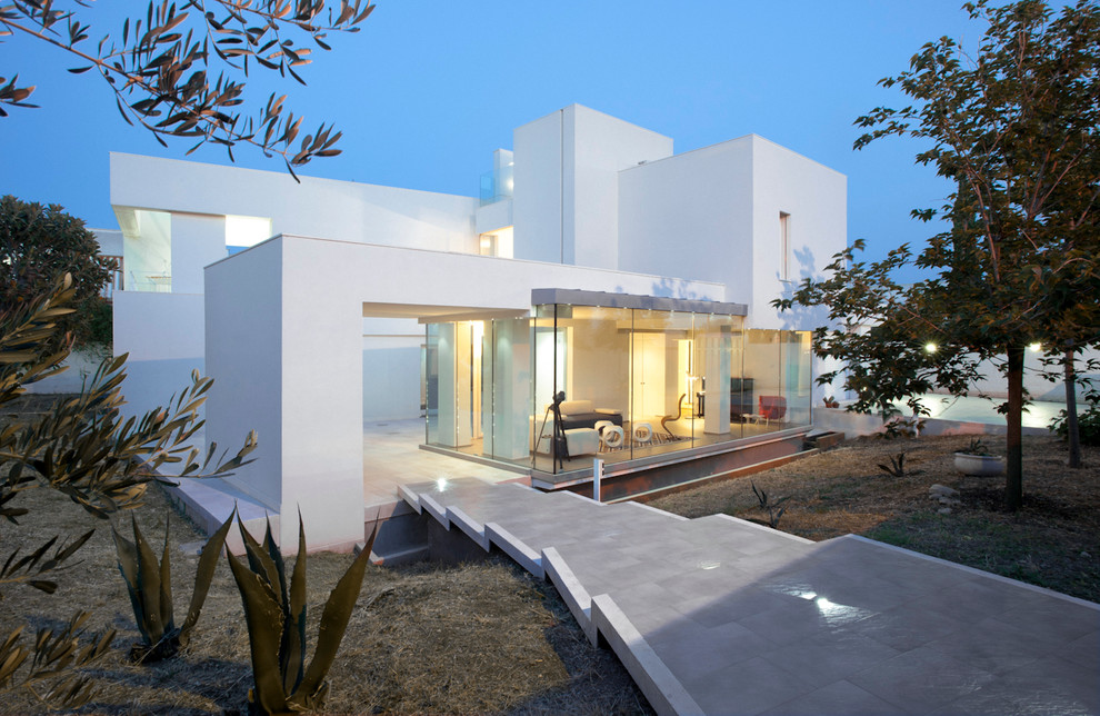 Idée de décoration pour une grande façade de maison blanche design à deux étages et plus avec un revêtement mixte et un toit plat.