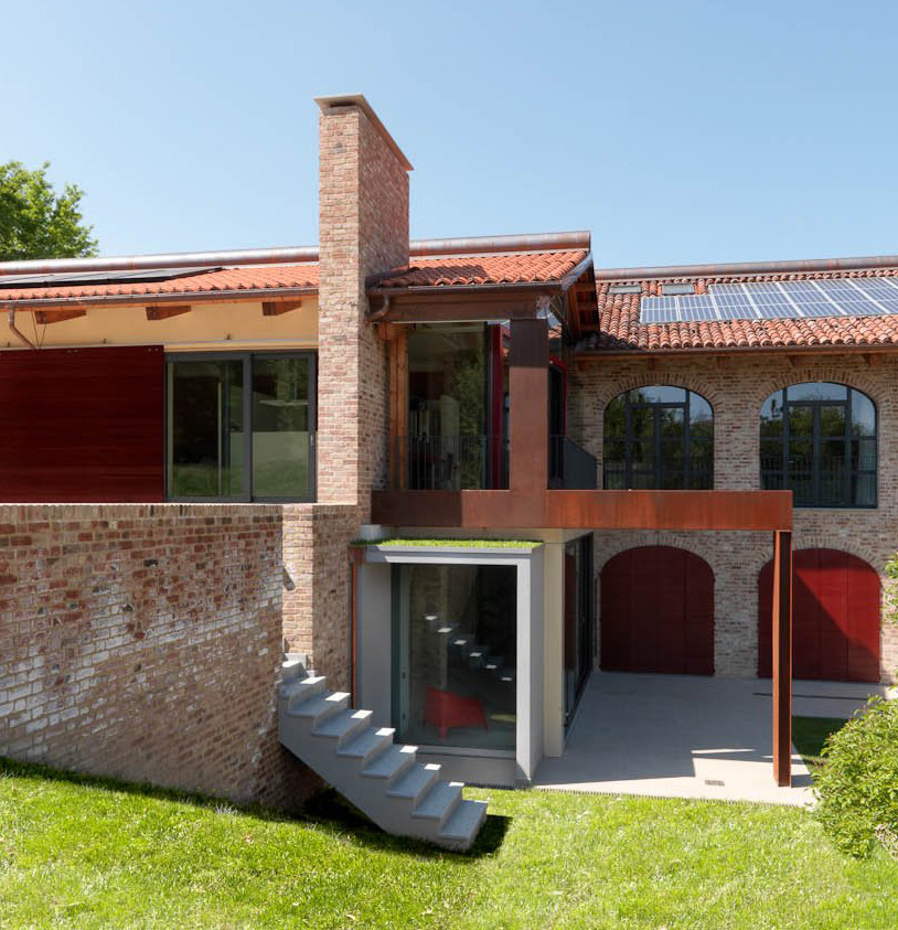 Cette photo montre une grande façade de maison marron nature en brique à un étage avec un toit à deux pans et un toit en tuile.