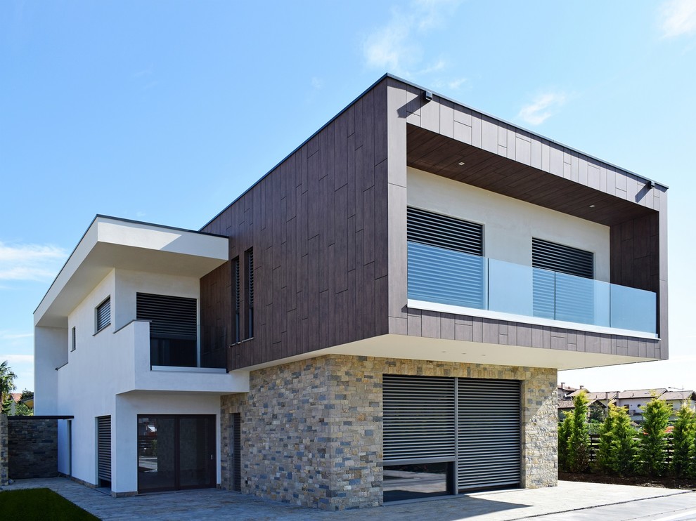 Ispirazione per la facciata di una casa moderna a due piani con rivestimento in pietra e tetto piano