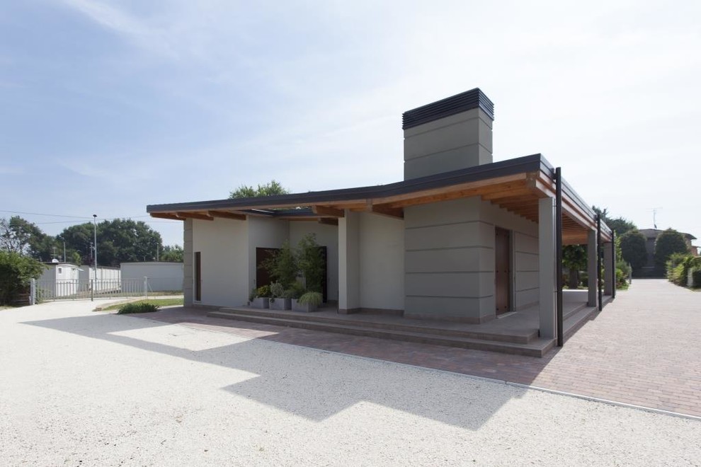 Imagen de fachada beige contemporánea de tamaño medio de una planta con revestimiento de piedra y tejado a doble faldón