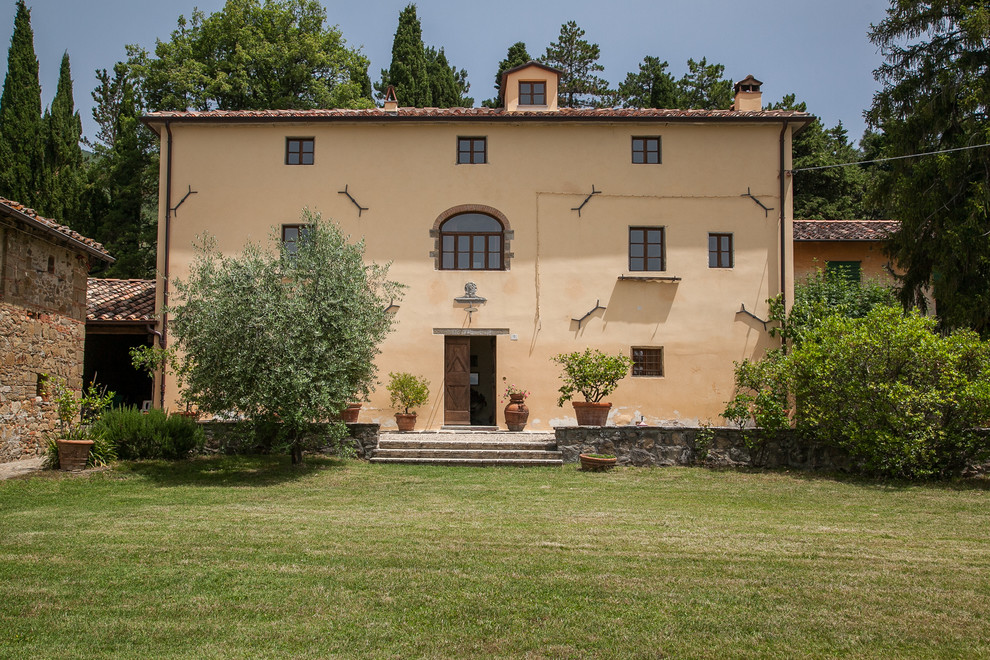 Mediterranes Einfamilienhaus mit gelber Fassadenfarbe, Satteldach und Ziegeldach in Sonstige