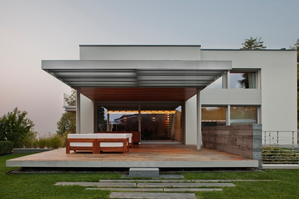 Réalisation d'une grande façade de maison beige design à deux étages et plus avec un revêtement mixte et un toit en appentis.