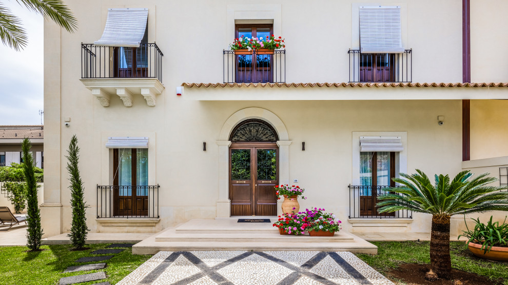 Exemple d'une façade de maison beige méditerranéenne.