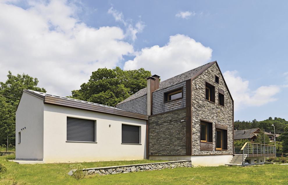 Foto della facciata di una casa marrone contemporanea a due piani di medie dimensioni con rivestimenti misti e tetto a capanna