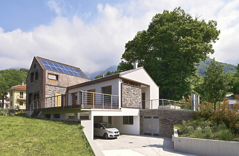 Ejemplo de fachada de casa gris contemporánea de tamaño medio de dos plantas con revestimiento de piedra, tejado a dos aguas y tejado de teja de madera
