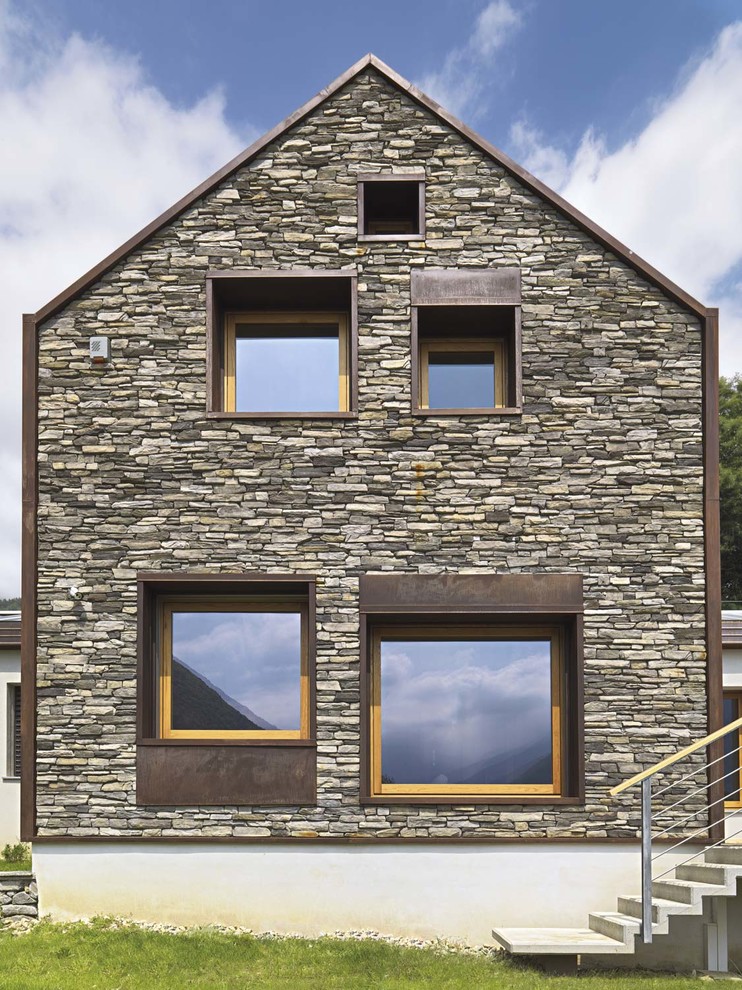 Imagen de fachada de casa gris contemporánea de tamaño medio de dos plantas con tejado a dos aguas, revestimiento de piedra y tejado de teja de madera