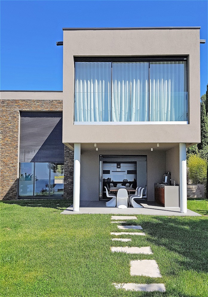 Idée de décoration pour une façade de maison grise design à un étage avec un revêtement mixte et un toit plat.