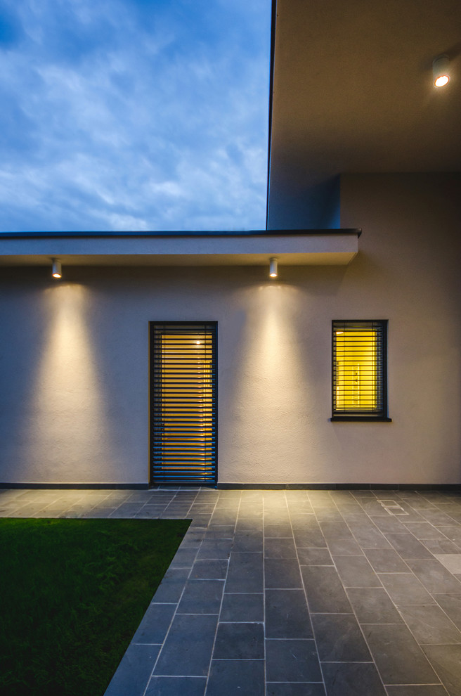 Foto de fachada de casa beige contemporánea grande de una planta con revestimiento de estuco y tejado plano