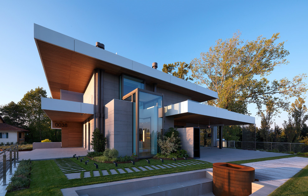 Modelo de fachada de casa gris actual de dos plantas con revestimientos combinados y tejado plano