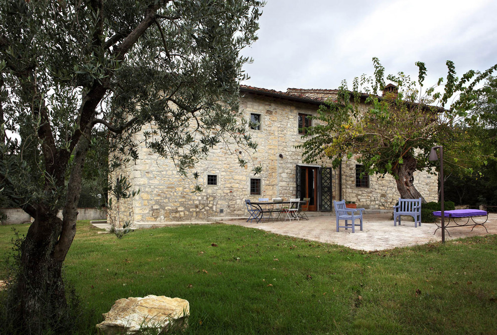 This is an example of a gey rural two floor house exterior in Florence with stone cladding.