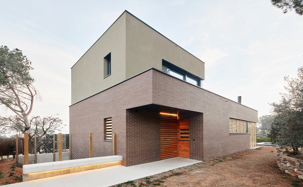 Diseño de fachada beige urbana de tamaño medio de dos plantas con revestimiento de ladrillo y tejado plano