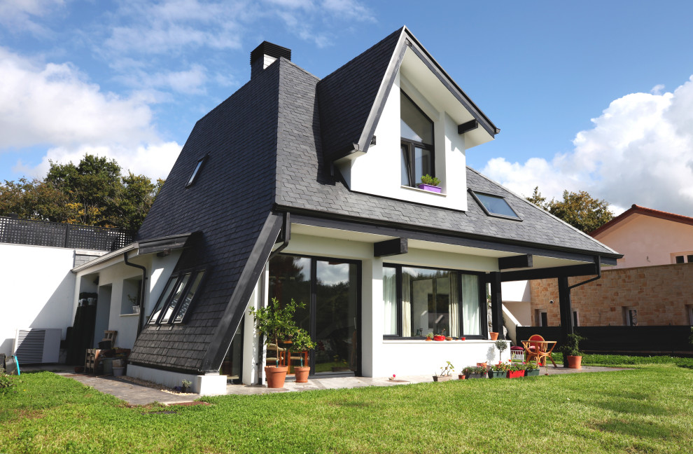 Стильный дизайн: двухэтажный, белый частный загородный дом среднего размера в скандинавском стиле с комбинированной облицовкой и полувальмовой крышей - последний тренд