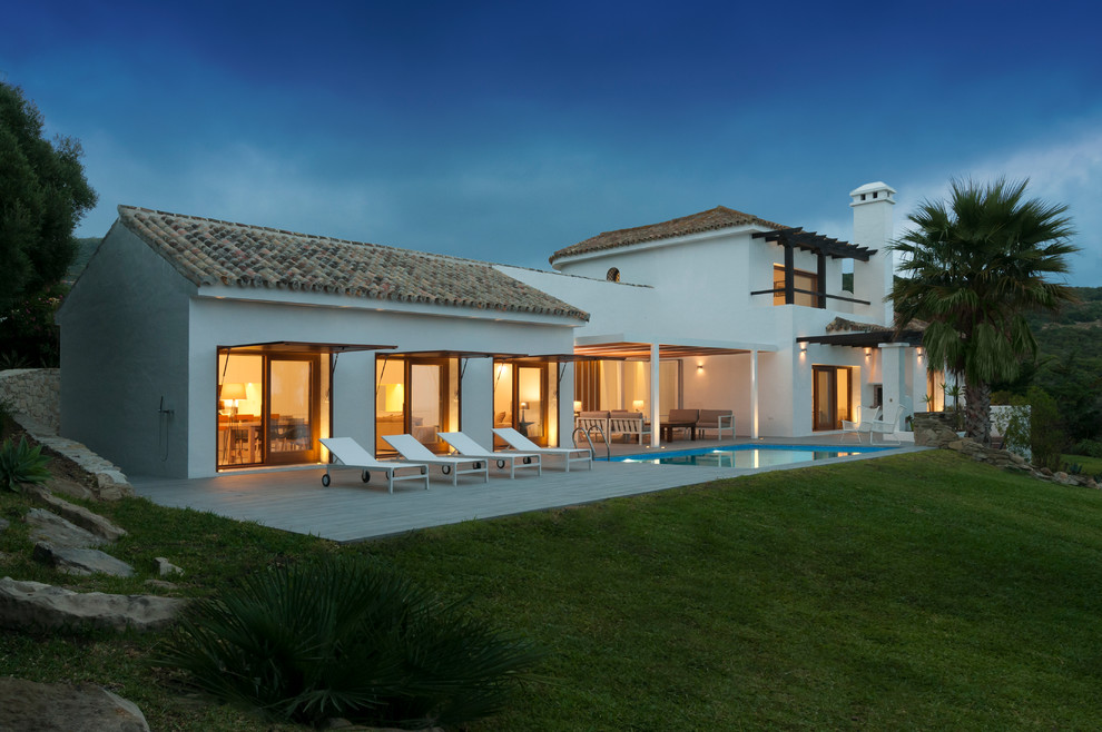 Источник вдохновения для домашнего уюта: двухэтажный, белый дом среднего размера в средиземноморском стиле с комбинированной облицовкой и двускатной крышей