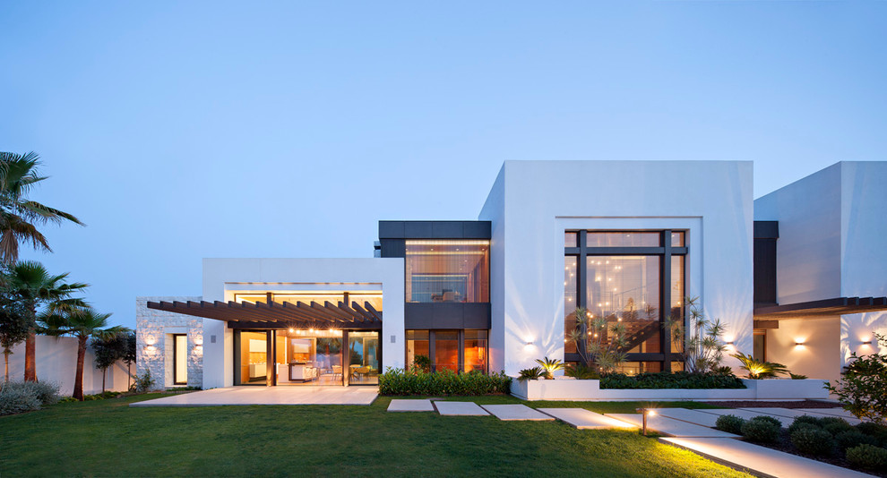 На фото: двухэтажный, белый, большой дом в современном стиле с комбинированной облицовкой и плоской крышей