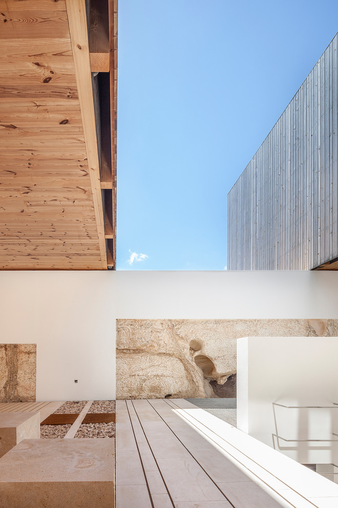 Ispirazione per la villa grigia mediterranea a due piani di medie dimensioni con rivestimento in legno, tetto piano e copertura mista