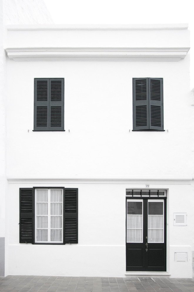 Foto de fachada blanca mediterránea de tamaño medio de dos plantas con revestimientos combinados y tejado plano