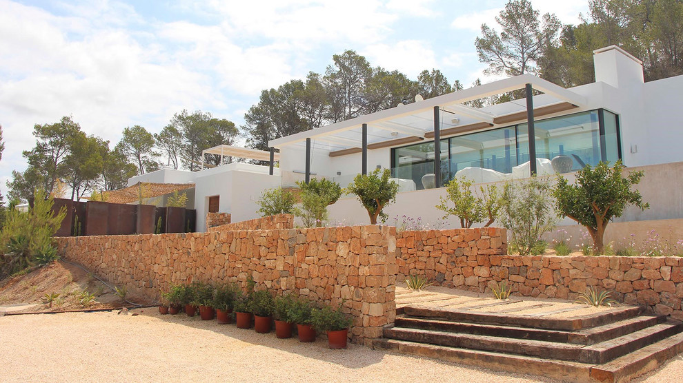 Imagen de fachada de casa blanca mediterránea grande de dos plantas con tejado plano