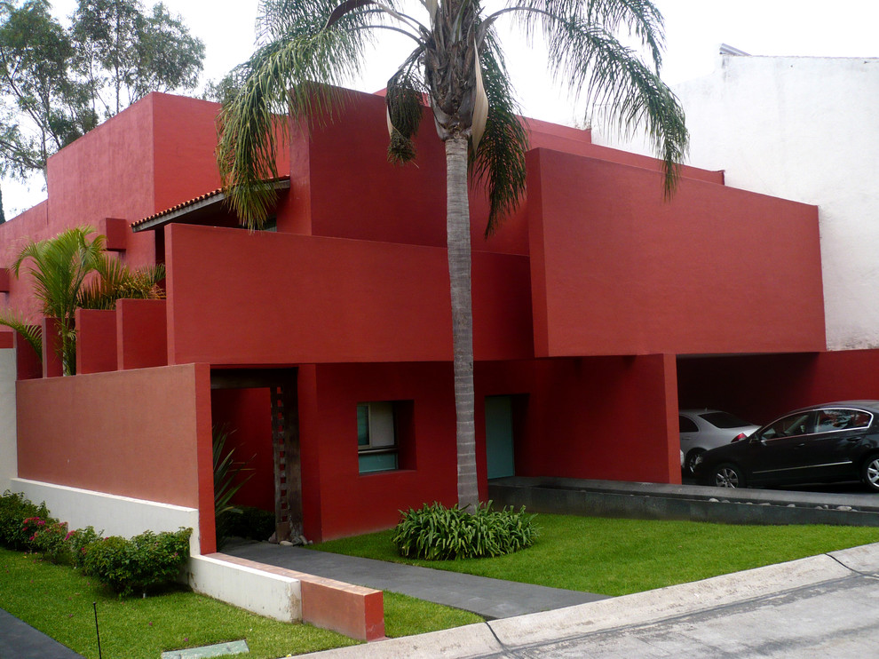 Cette image montre une façade de maison marron design en stuc de taille moyenne et à deux étages et plus avec un toit à deux pans.