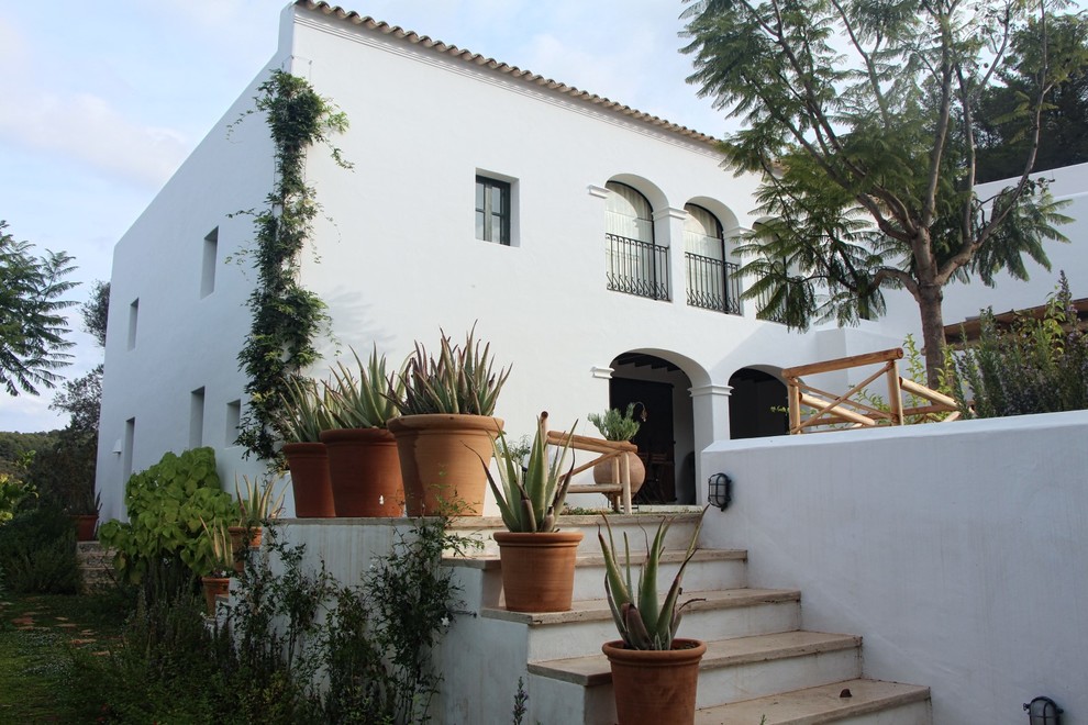 Diseño de fachada de casa blanca mediterránea de dos plantas con tejado de teja de barro y tejado plano