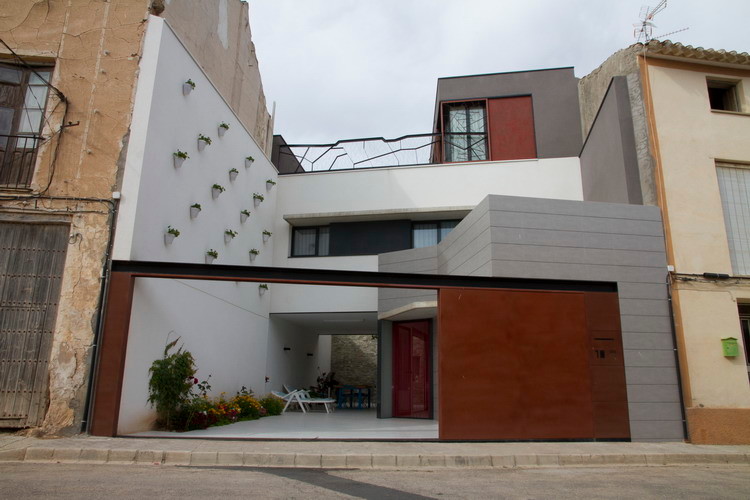 Modelo de fachada blanca minimalista de tamaño medio de tres plantas con revestimientos combinados y tejado plano