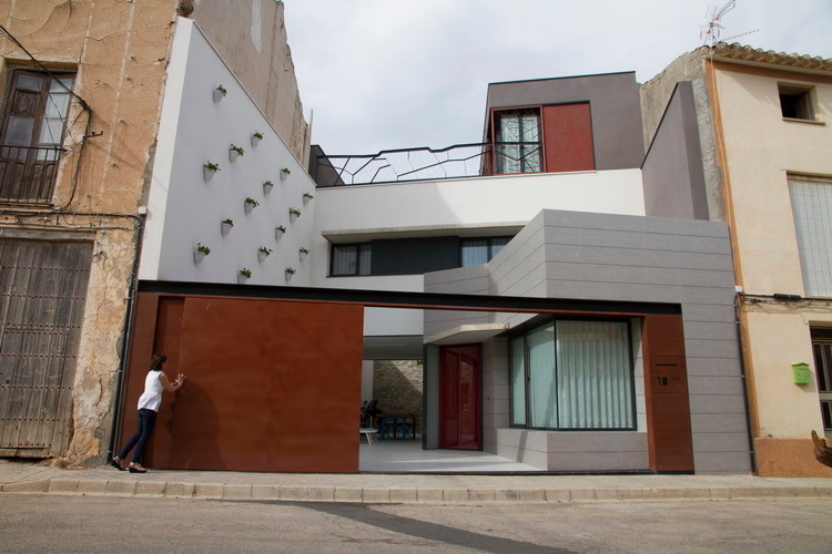 Imagen de fachada blanca moderna de tamaño medio de tres plantas con revestimientos combinados y tejado plano