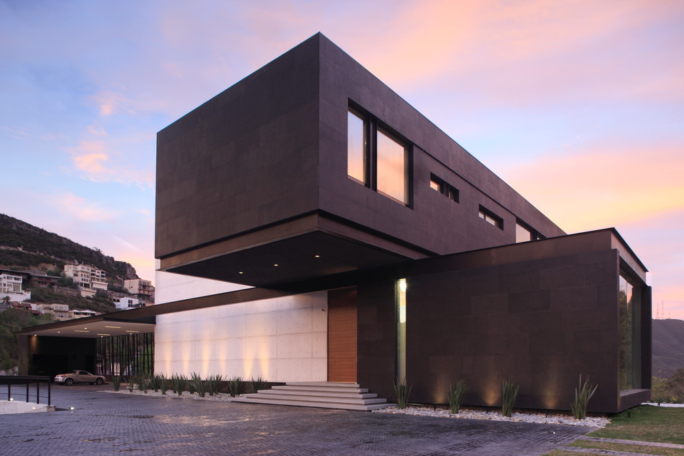 Idée de décoration pour une façade de maison noire design à un étage avec un revêtement mixte et un toit plat.