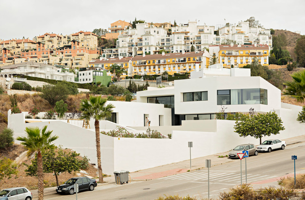 Esempio della villa grande bianca contemporanea a due piani con tetto piano e tetto bianco
