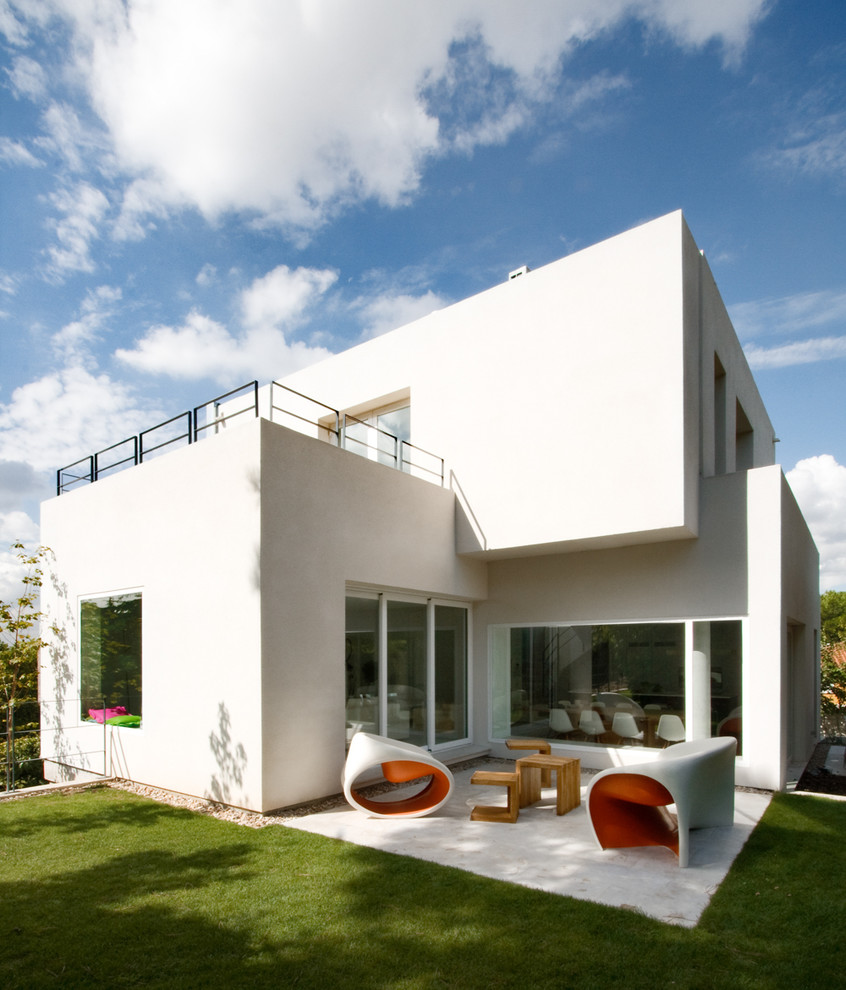 Inspiration för mellanstora moderna vita hus, med två våningar, stuckatur och platt tak