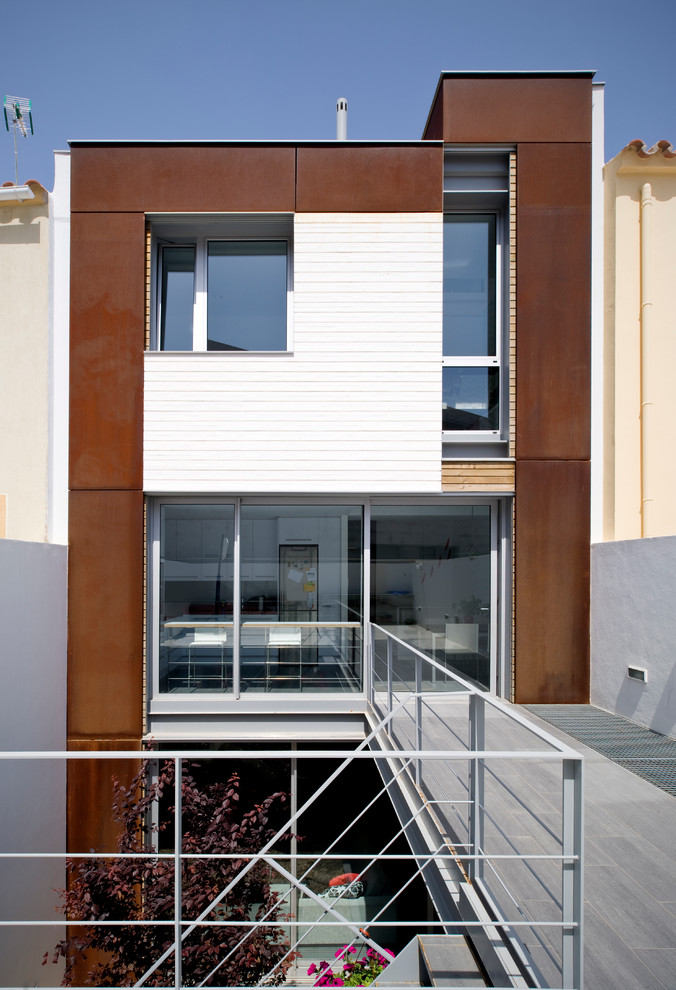 Réalisation d'une façade de maison marron design à deux étages et plus et de taille moyenne avec un revêtement mixte et un toit plat.
