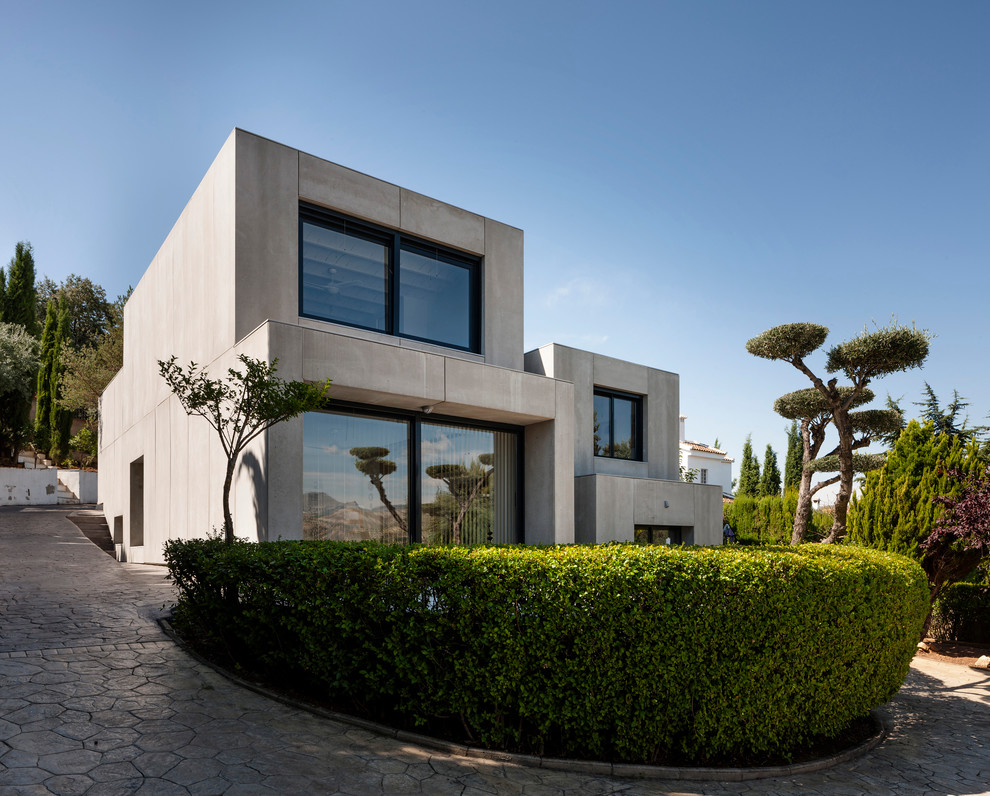 Large and gey contemporary concrete house exterior in Other with three floors and a flat roof.