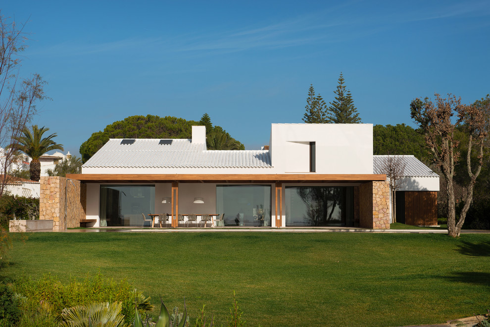 Cette photo montre une très grande façade de maison blanche méditerranéenne avec un toit en tuile.