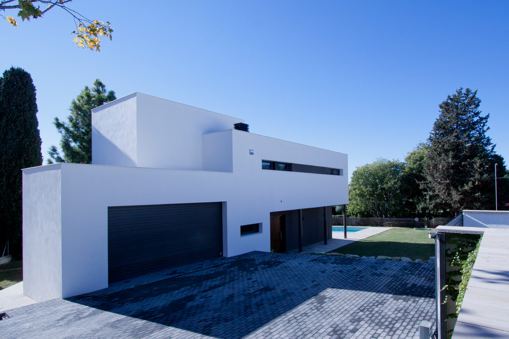 Réalisation d'une façade de maison blanche design de taille moyenne et à un étage avec un toit plat.