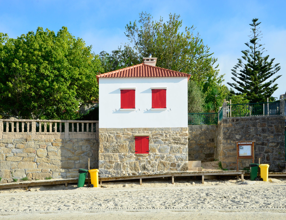 Inspiration pour une petite façade de maison blanche marine en pierre à un étage avec un toit à deux pans et un toit en tuile.