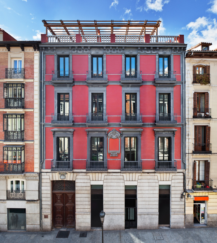 Großes, Dreistöckiges Klassisches Haus mit Mix-Fassade, roter Fassadenfarbe und Flachdach in Madrid