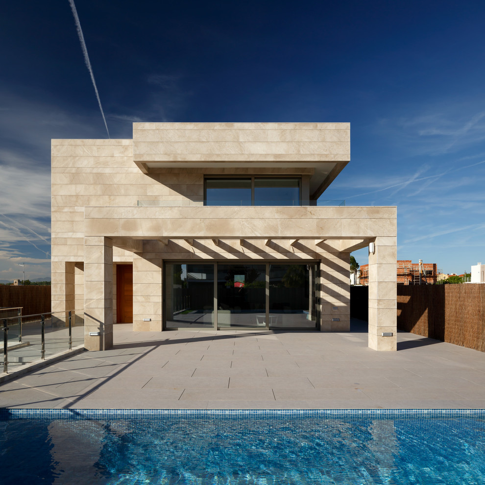 Idées déco pour une grande façade de maison beige moderne en pierre à un étage avec un toit plat et un toit mixte.