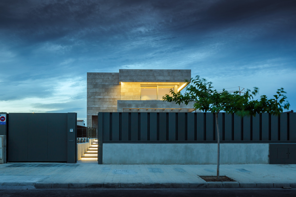 Ejemplo de fachada de casa beige minimalista grande de dos plantas con revestimiento de piedra, tejado plano y tejado de varios materiales