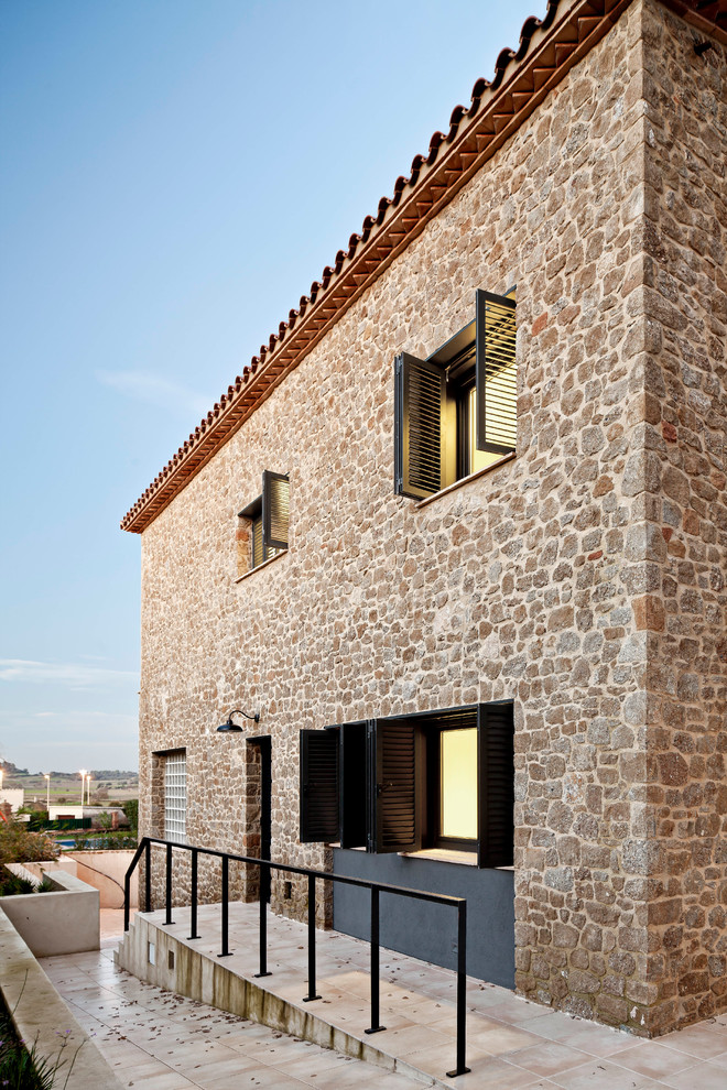 Mittelgroßes, Zweistöckiges Rustikales Haus mit Steinfassade, brauner Fassadenfarbe und Satteldach in Barcelona