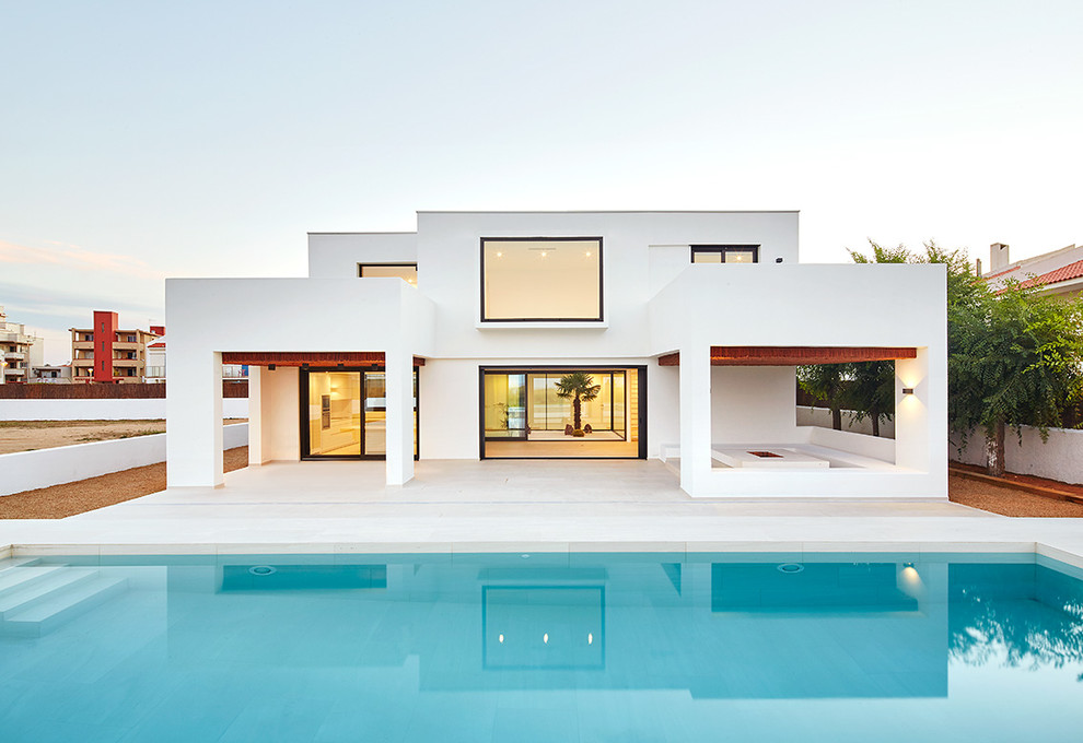 Идея дизайна: двухэтажный, белый дом среднего размера в средиземноморском стиле с плоской крышей и облицовкой из цементной штукатурки