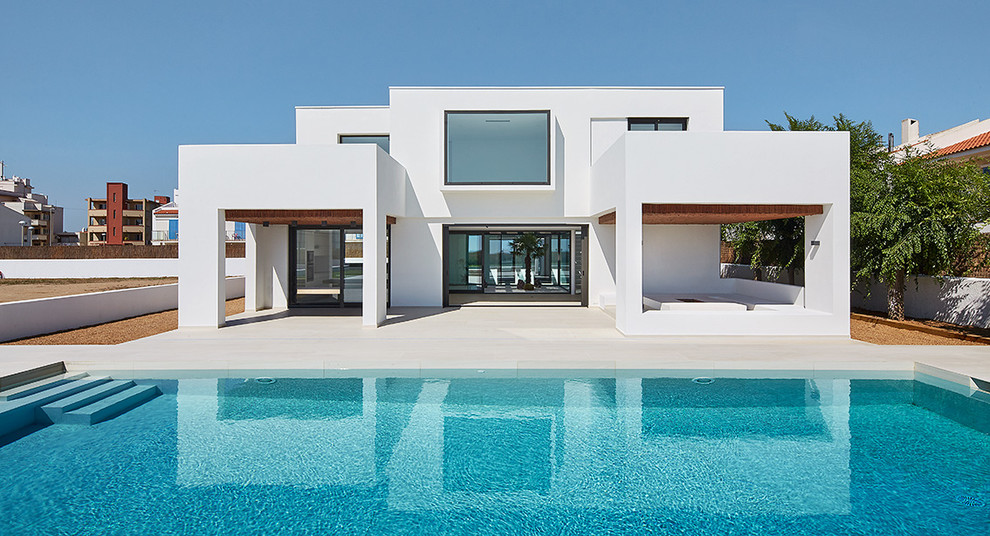 Mittelgroßes, Zweistöckiges Mediterranes Haus mit Putzfassade, weißer Fassadenfarbe und Flachdach in Sonstige