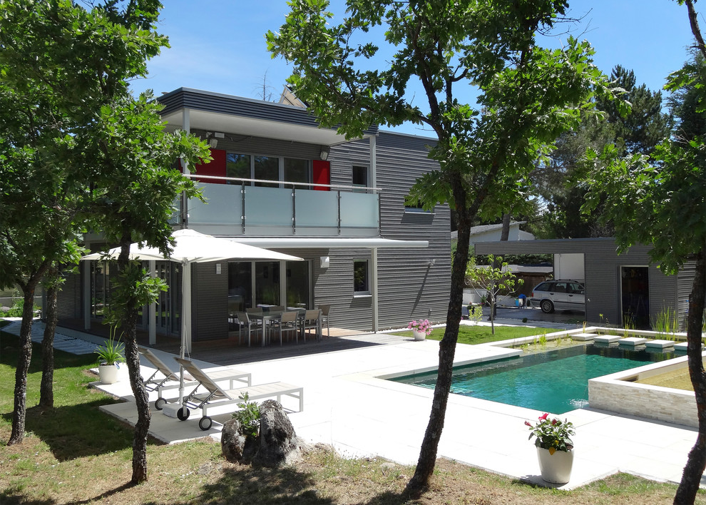 Mittelgroßes, Zweistöckiges Modernes Haus mit grauer Fassadenfarbe, Flachdach und Misch-Dachdeckung in Sonstige