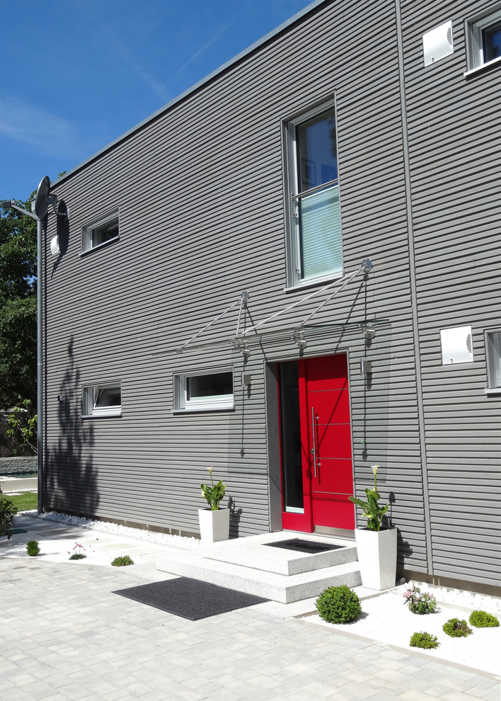Ejemplo de fachada de casa gris actual de tamaño medio de dos plantas con revestimiento de madera y tejado plano
