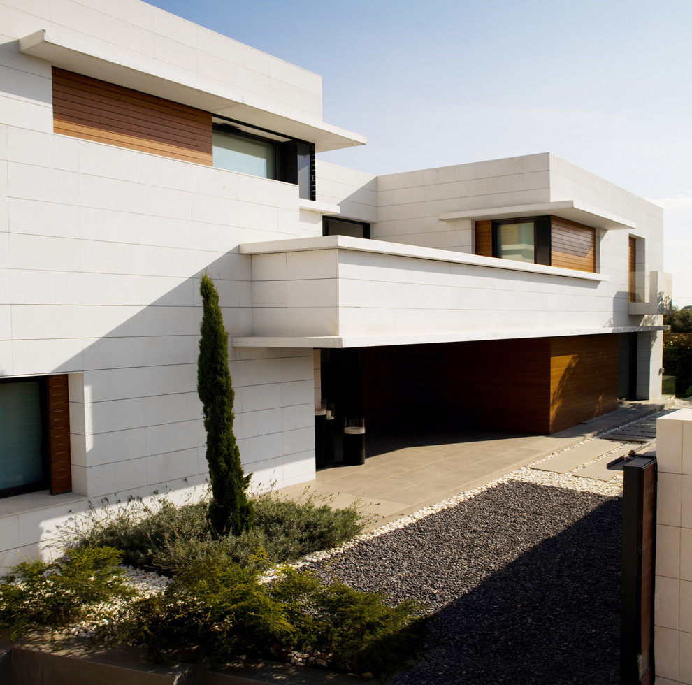 Cette image montre une grande façade de maison blanche design en pierre à un étage avec un toit plat.