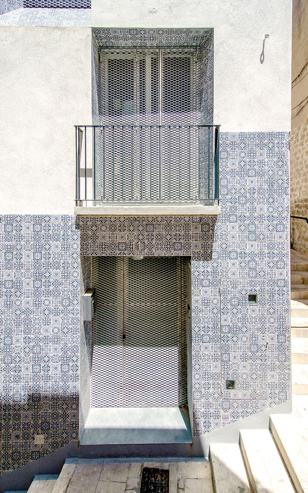 Пример оригинального дизайна: синий, трехэтажный дом среднего размера в средиземноморском стиле с плоской крышей и облицовкой из бетона