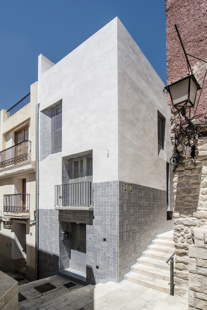 Exemple d'une façade de maison grise méditerranéenne en béton de taille moyenne et à deux étages et plus avec un toit plat.