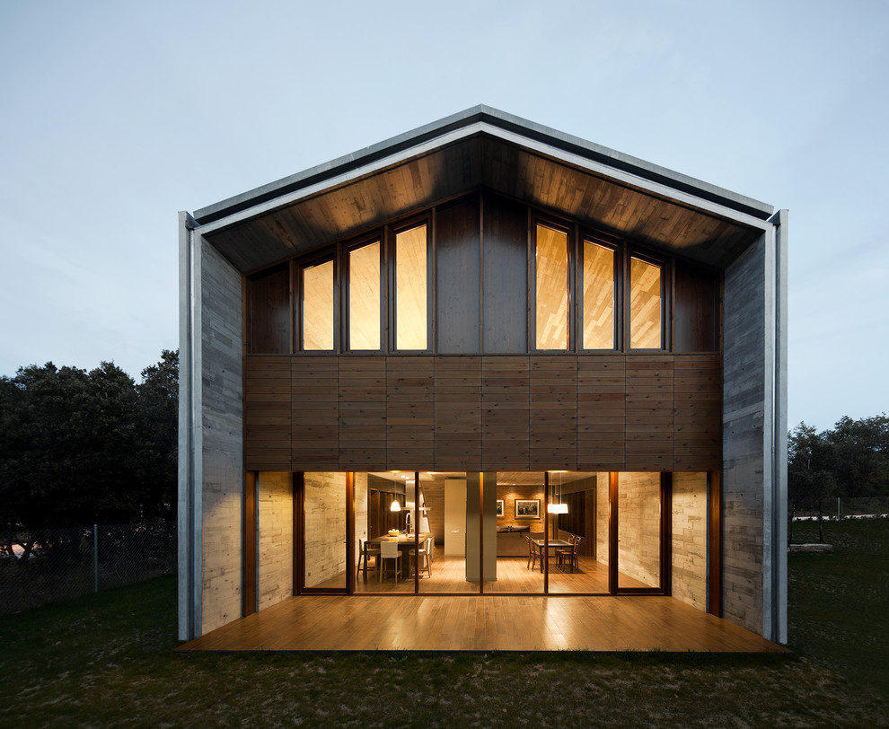 На фото: большой, двухэтажный, серый дом в стиле лофт с комбинированной облицовкой и двускатной крышей с