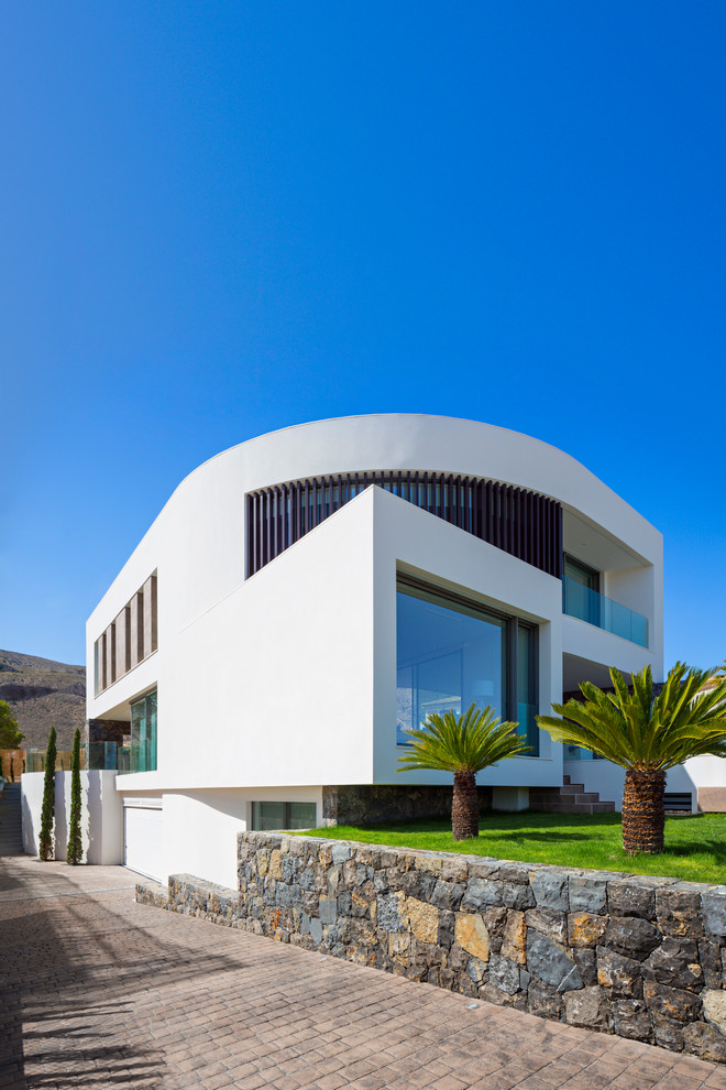 На фото: большой, двухэтажный, белый дом в современном стиле с комбинированной облицовкой